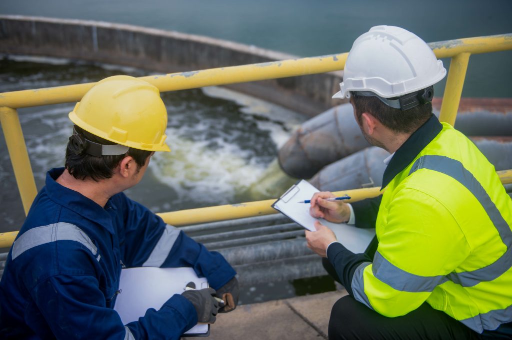 Contrôle technique environnemental dans une station d'épuration par deux ingénieurs en tenue de sécurité