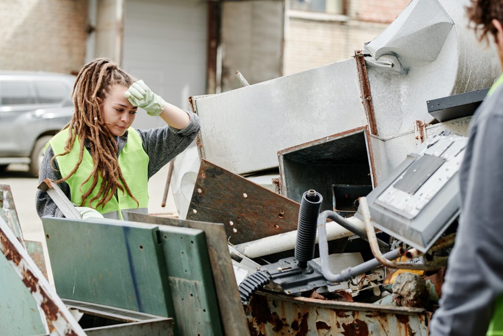 Employée sélectionnant des matériaux dans un centre de tri, illustrant la gestion des déchets et le recyclage